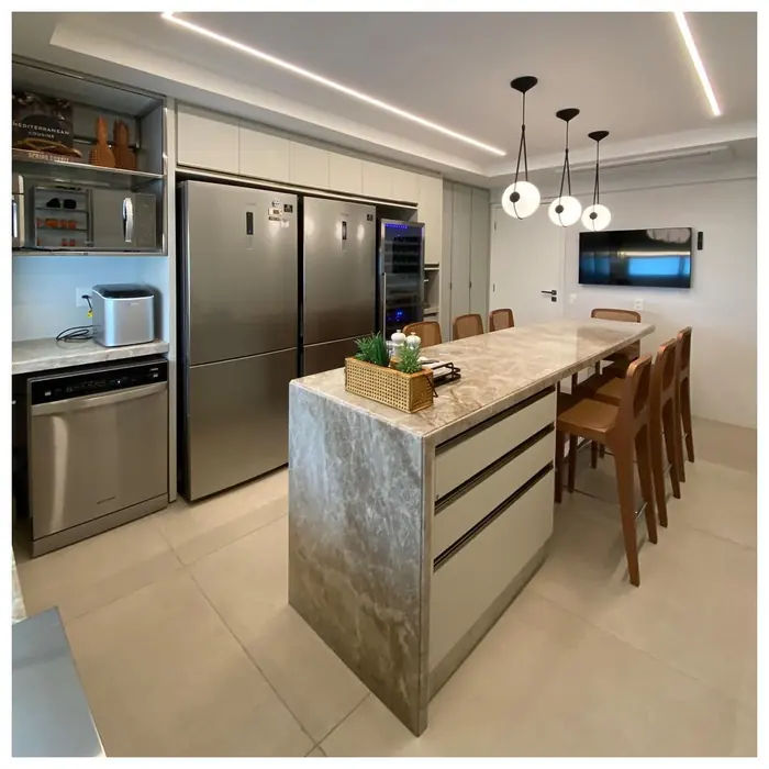 Kitchen with waterfall-edge island, long cabinet run and pendant lights